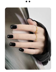 Detail of two stacked rings with gold and silver irregular textured finish on a finger
