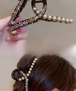 Detail of elegant hair claw clip with white pearls and rhinestones on resin