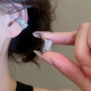 Close-up of silver zircon star flower ear cuffs worn on cartilage without piercing