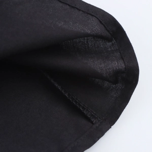 Gros plan des coutures de qualité sur l'ourlet de la mini robe noire dos nu