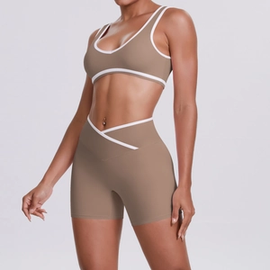 Detail of light brown yoga set with white trim, featuring cross-waist shorts and U-neck bra