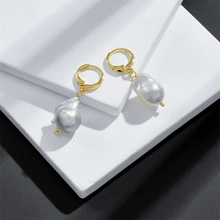Detailed macro view of baroque grey pearl earrings with 14K gold plated hoops