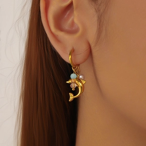 Golden dolphin beaded earrings with blue charms and white pearls on model ear