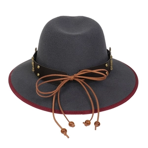 Detail of grey wool fedora featuring a brown leather band with gold rivets and wood beads