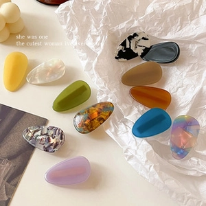 Flat lay of 12 colorful leopard and matte acrylic BB hair clips on a white paper background