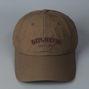 Detail of embroidered lettering on brown quick-dry baseball cap with vintage texture