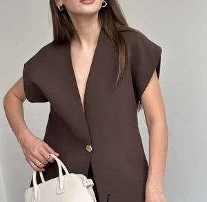 Detail of dark brown sleeveless waist-trimming vest with a single gold button accent