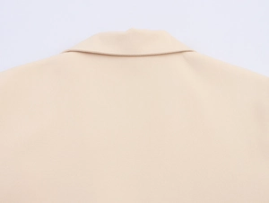 Detailed close-up of the beige blazer back collar showing clean seams and fine fabric