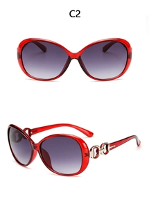 Detail of red oversized sunglasses with gradient purple lenses and metal chain temples