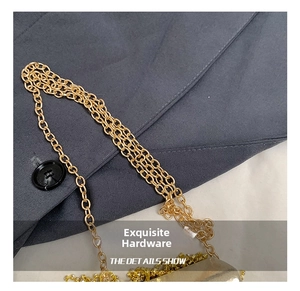 Detail of elegant gold metal chain strap with tassel fringe on rhinestone evening bag