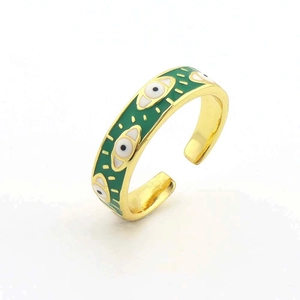 Dettaglio di un anello regolabile placcato in oro con smalto verde e motivi malocchio
