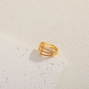 Macro detail of 14K gold plated layered criss-cross ring with zircon pavé setting