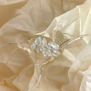 Minimalist S925 sterling silver flower ear clips with hammered texture on crepe paper