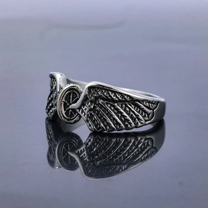 Retro stainless steel punk wing ring with wheel detail on a reflective surface