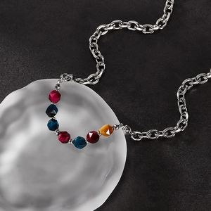 Detailed macro view of faceted colorful natural stones on a silver stainless steel chain