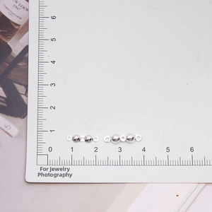 Macro view of S925 sterling silver jewelry clasps on measuring card with metric scale