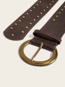 Détail d'une ceinture en cuir marron foncé avec boucle dorée et rivets métalliques doubles