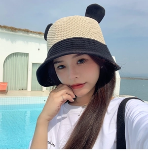 Outdoor shot of a panda ear fisherman hat with beige and black contrast knit design