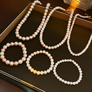 Detailed display of natural pearl necklace and bracelet set in white and lavender tones