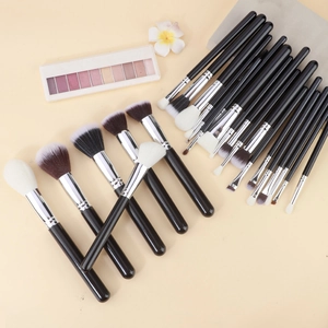 Detail of 25 professional makeup brushes with black handles and grey storage pouch