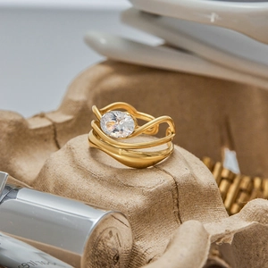 Macro shot of a gold layered wave ring featuring a large oval cubic zirconia gemstone