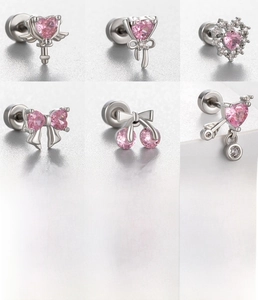 Macro detail of six pink zircon stud earrings in silver-tone titanium steel with CZ inlay