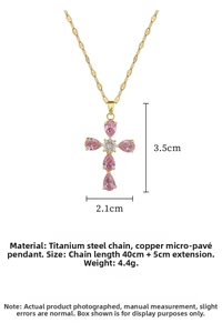 Macro detail of cross pendant featuring pink teardrop zircons and gold titanium steel chain