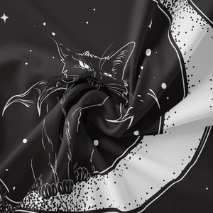 Close-up of soft gothic black cat tapestry fabric with mystical moon and star patterns