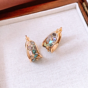 Detail of 18K gold plated U-shaped earring with mother of pearl and zircon stones