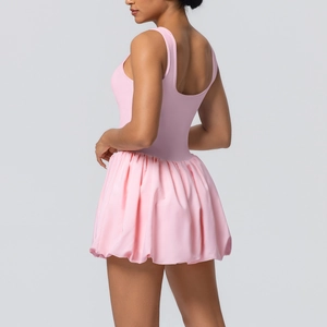 Detail view of the pink athletic dress showing the racerback design and pleated bubble hem