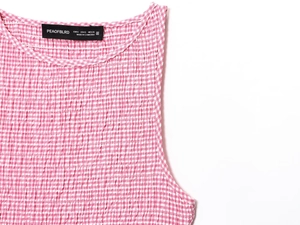 Détail d'une robe midi vichy rose avec tissu gaufré texturé et étiquettes de col