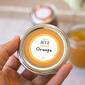 Waterproof orange food date labels on glass jar lids for kitchen organization