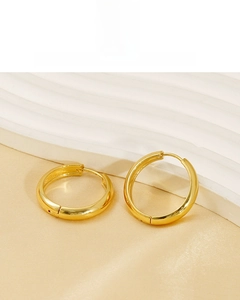 Macro view of polished 18K gold plated stainless steel hoop earrings on a silk backdrop