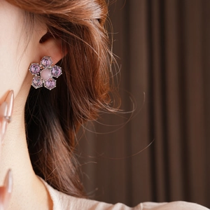 Gros plan d'une boucle d'oreille fleur en cristal rose et perle sur un mannequin