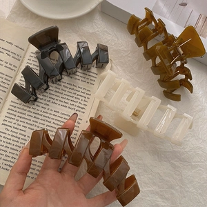 Set of four 13cm oversized acrylic hair claws in black, amber, cream and dark brown tones