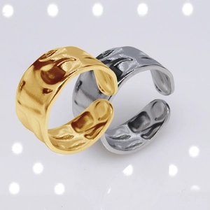 Close-up of gold and silver open rings featuring a unique hammered metal texture finish