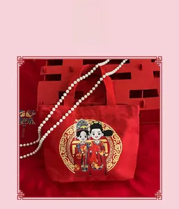 Detail of red wedding canvas gift bag with cartoon bride groom and pearl chain handle