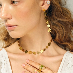 Nahaufnahme eines Models mit 18k Gold Gänseblümchen Schmuckset aus Kette und Ohrringen