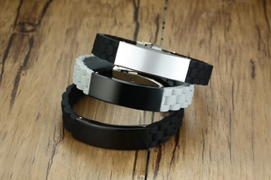 Close-up of silicone bracelets with blank stainless steel plates in black and white