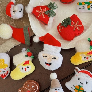 Assorted Christmas plush DIY patches including Santa and gingerbread man on a rustic table