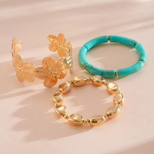 Detailansicht eines 3-teiligen Schmucksets mit Goldblumen-Manschette und Perlen