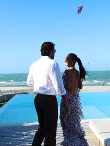 Detail von Polka-Dot-Rückenfrei-Kleid und weißem Hemd an einem luxuriösen Infinity-Pool-Strand
