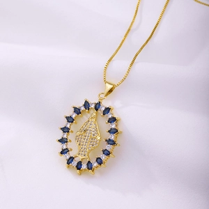 Vue détaillée d'un pendentif Vierge Marie doré avec des zircons bleus et une chaîne fine