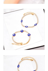 Macro detail of gold evil eye bracelet with blue enamel charms and clear crystals