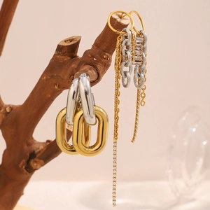 Detailed close-up of 18K gold plated chain earrings and tassel studs on a wooden branch