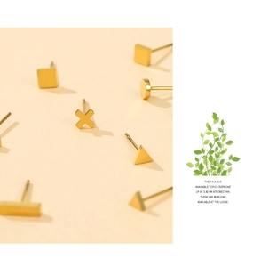 Detailed view of geometric gold stud earrings in square, triangle and cross shapes