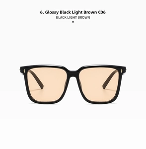 Front view of large square black frame sunglasses with light brown lenses and gold rivets