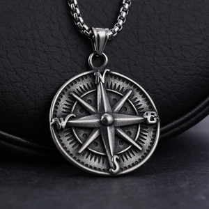 Macro shot of vintage stainless steel compass pendant with distressed metal texture