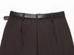 Gros plan du short marron foncé avec ceinture en cuir assortie et détails à la taille