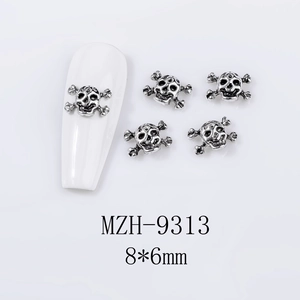 Detailed retro silver skull nail art charm with cross-bones on white manicure, 8x6mm size